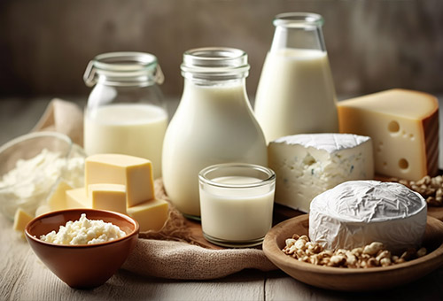 Frische Molkereiprodukte wie Milche, Sahne und Käse stehen auf einem Tisch