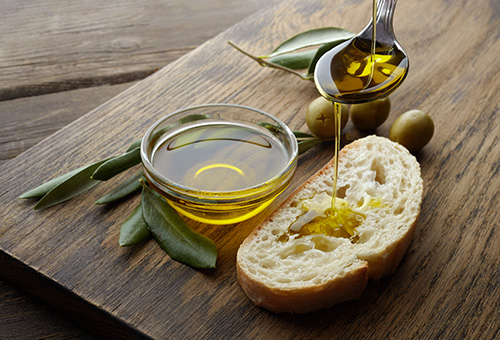 Eine Scheibe Ciabatta, die mit Olivenöl beträufelt wird