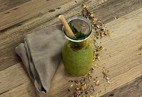 Grüner Smoothie frisch zubereitet im Glas angerichtet